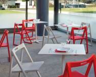 Krzesła składane Enjoy 460 marki Pedrali białe i czerwone w kawiarni